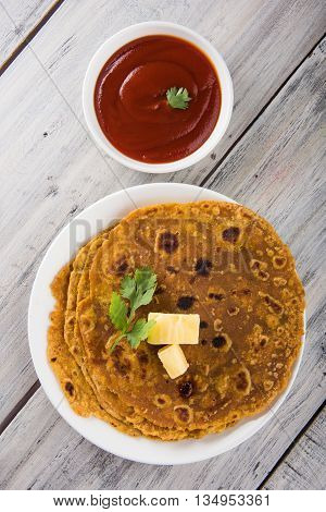 Hot delicious paratha with ghee and tomato sauce