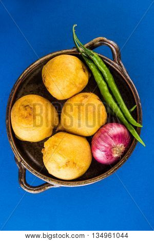 batata vada or aalu bonda or aalu bonde, a tasty indian snacks, served with tomato ketchup or green chilli and onion