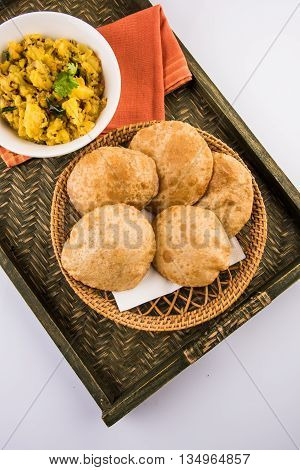 indian semi dry potato spicy recipe also known as aalu bhaji or aalu sabji served with indian puri or poori