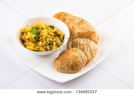 indian semi dry potato spicy recipe also known as aalu bhaji or aalu sabji served with indian puri or poori