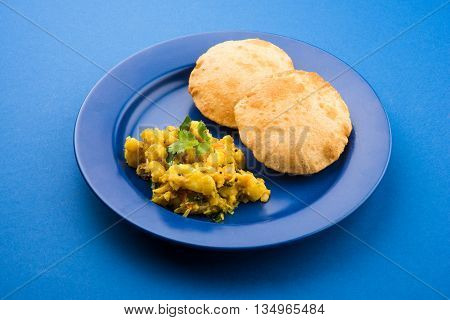 indian semi dry potato spicy recipe also known as aalu bhaji or aalu sabji served with indian puri or poori
