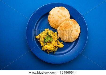 indian semi dry potato spicy recipe also known as aalu bhaji or aalu sabji served with indian puri or poori