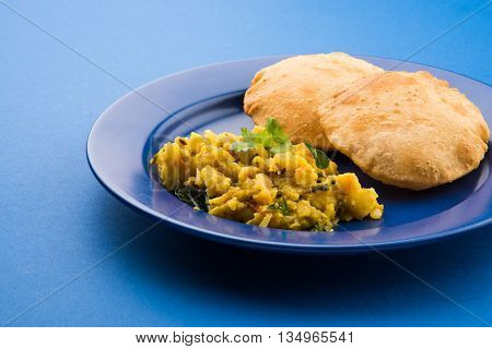 indian semi dry potato spicy recipe also known as aalu bhaji or aalu sabji served with indian puri or poori