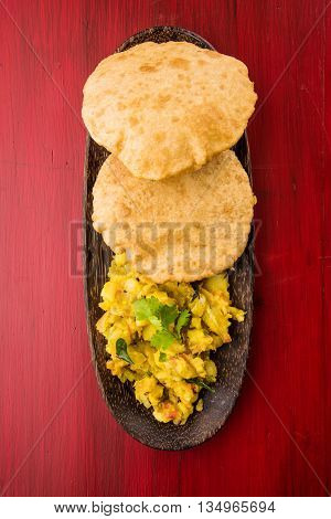 indian semi dry potato spicy recipe also known as aalu bhaji or aalu sabji served with indian puri or poori
