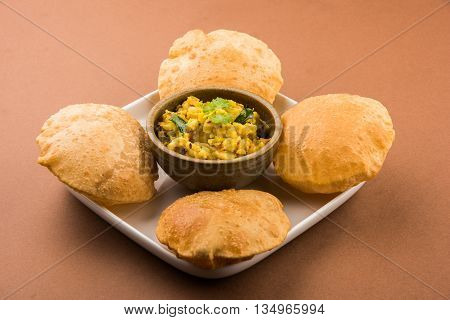 indian semi dry potato spicy recipe also known as aalu bhaji or aalu sabji served with indian puri or poori