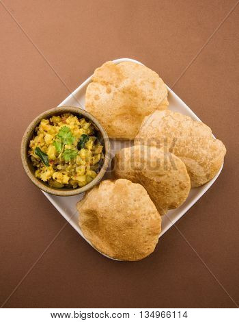 indian semi dry potato spicy recipe also known as aalu bhaji or aalu sabji served with indian puri or poori