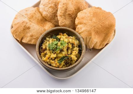indian semi dry potato spicy recipe also known as aalu bhaji or aalu sabji served with indian puri or poori