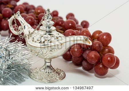 Silver Aladdin's magic lamp and red grapes. Ramadan Eid concept background