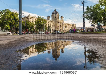 VIENNA AUSTRIA - 12TH JUNE 2016: The outside of the KH Museum in Vienna. Reflections can be seen in a puddle. People can be sen in the distance.