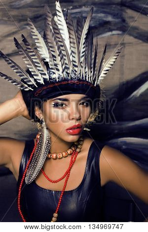 young pretty woman with make up like red indian, futher in hair, fashion hallowen concept creative