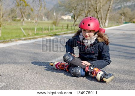 young attractive teenage skater grimacing in pain after taking a fall