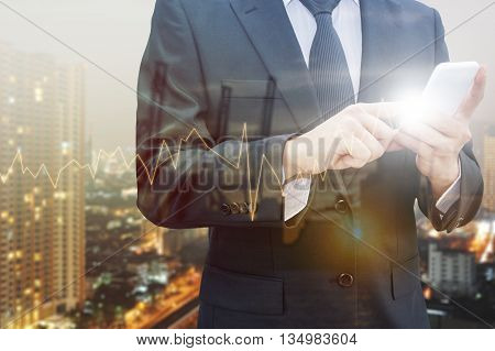 Double exposure of professional businessman using smart phone blurred city centre of business and blurred tranportation port with trading graph chart Technology & Business trading concept