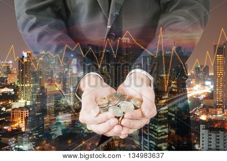Double exposure of cityscape and businessman collect many coins on hands with trading graph finance and banking concept