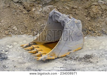 A Old Dredger Bucket On Loamy Ground