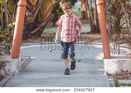 Happy Little Boy  Playing Mini Golf.