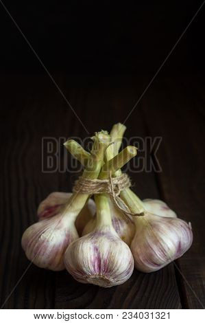 Garlic Heads On A Dark Wooden Table
