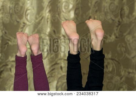 Two Pairs Of Children Bare Teet Sticking Up.
