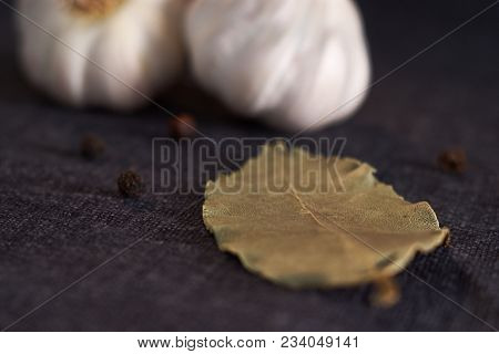 Onion, Garlic, Black Pepper And Bay Leaf On A Black