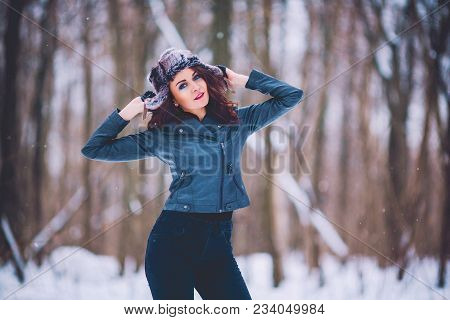 Girl Brunette Against The Background Of The Winter Forest