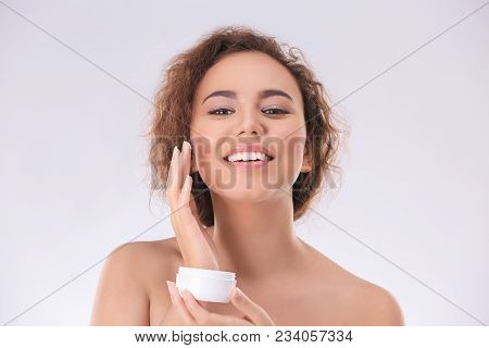 Beautiful Young Woman With Problem Skin Applying Anti Acne Cream On Light Background