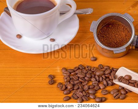 Mug, Dispenser With Coffee, Wooden Spoon And A Scattering Of Coffee Beans On A Wooden Background
