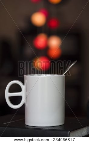 Close Up White Coffee Cup On The Book And Colorful Blur Light Bokeh In Dark Background