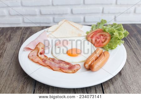 Close Up Breakfast Set With Bacon Fried Egg And Ham On Wooden Table Background