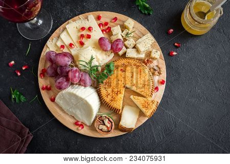 Cheese Platter With Assorted Cheeses, Grapes, Nuts Over Black Background, Copy Space. Italian Cheese