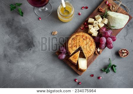 Cheese Platter With Assorted Cheeses, Grapes, Nuts Over Black Background, Copy Space. Italian Cheese
