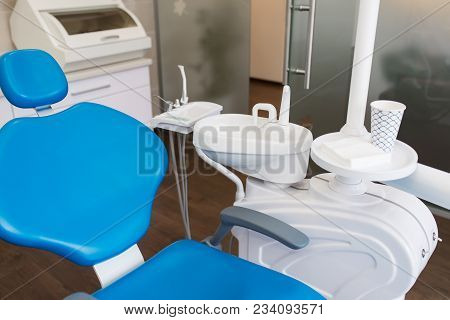 Blue Dental Chair In White Dental Clinic.