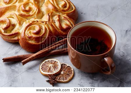 Festive Composition Of Homemade Rose Bread With Raisins, Cup Of Tea, Dried Citrus, Anise And Cinnamo