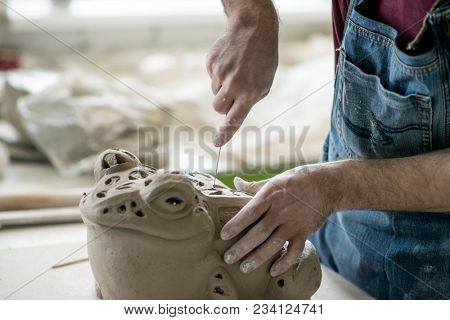 Ceramist Dressed in an Apron Sculpting Statue from Raw Clay in the Bright Ceramic Workshop.