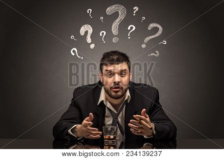 Young drunk disappointed man with question signs concept