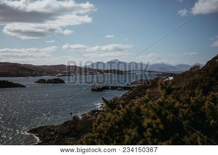 View Of Skye Bridge And A Small Coastal Village On Isle Of Skye, Scotland, On A Sunny Day. View From