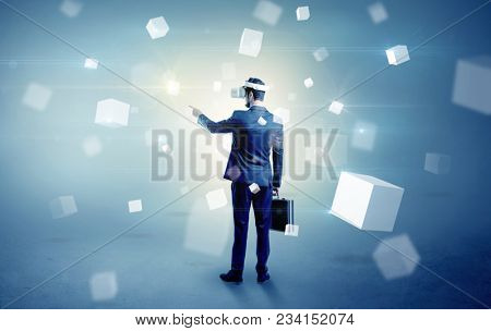 Handsome businessman with vr goggle and falling white cubes around