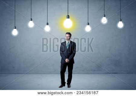 Handsome businessman in an empty space with bulbs above and uninspired face