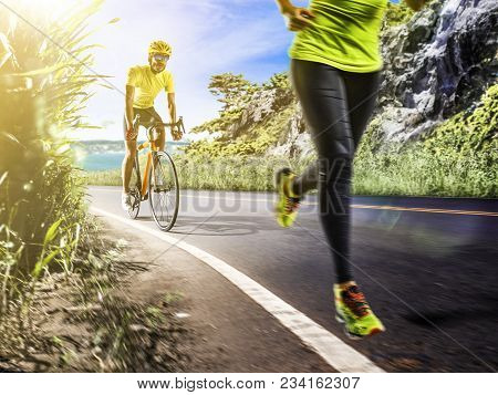 Professional Triathlon Man And Woman Running And Ciclyng Outdoor