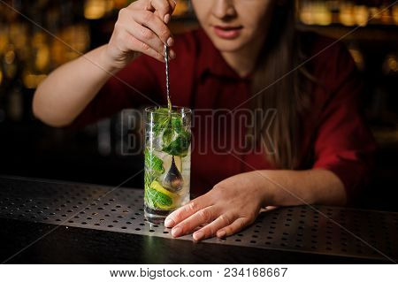 Barmaid With Pink Manicure Mixes An Alcoholic Cocktail Mojito With A Silver Spoon In A Crystal Glass