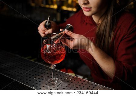 Barmaid At A Bar Counter Prepares An Alcoholic Cocktail Spritz Veneziano, Using Red Wine, Ice And A 