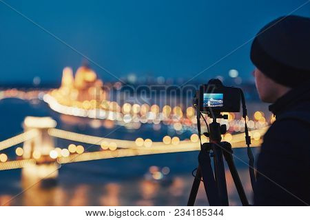 Photographer With Tripod. Young Man Taking Photo With His Camera In The Night City. Budapest, Hungar