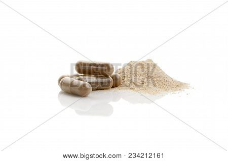 Heap Of Gotu Kola Powder With Gel-capsules For Healthy Supplement Eating. Isolated On White Backgrou