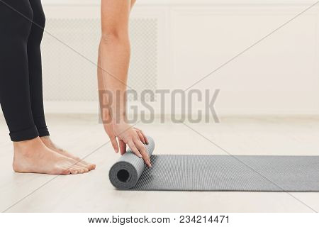 Pilates Background. Unrecognizable Woman Rolling Up Yoga Mat After Training. Sport Class Before Or A