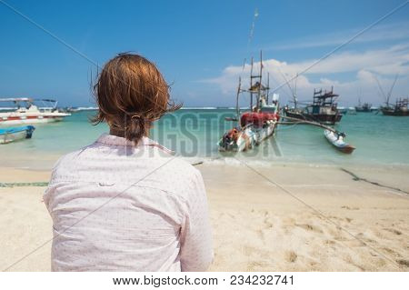 Caucasian Woman Standing On The Beach Of Midigama And Looking On Ocean And Traditional Colourful Loc
