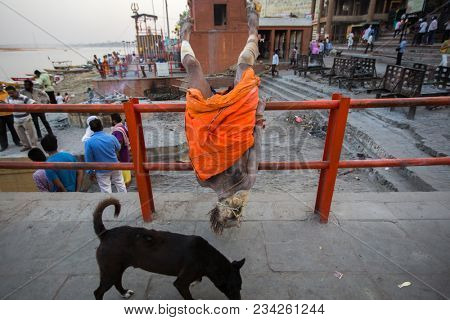 VARANASI, INDIA - MAR 26, 2018: Sadhu or Baba (holy man) on the ghats of Ganges river. Normally a sadhu is a monk, renounced, renounced material enjoyment. In India from 4 to 5 million sadhu.