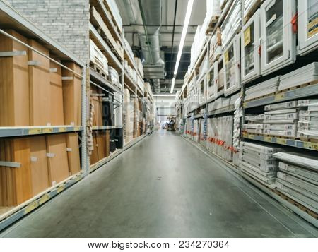 Abstract Blurred Hardware Store Aisle With Finishing Material Shelves And Unrecognizable Customers A
