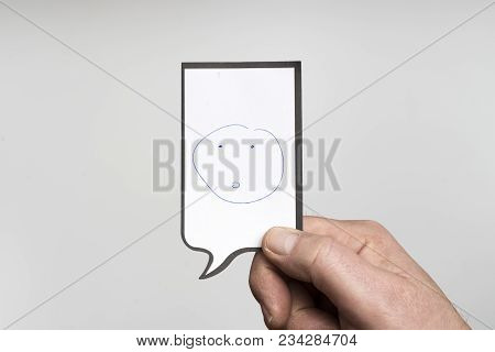 a small piece of paper with a drawing of a smiling face