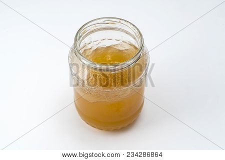 A Glass Jar Containing Some Yellow Honey