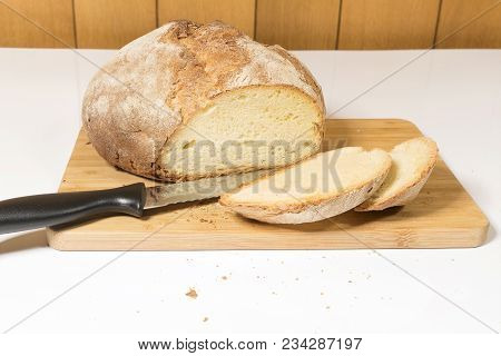 A Loaf Of Sliced Bread On A Wooden Cutting Board