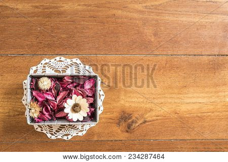a basket with dried flowers on the wooden floor