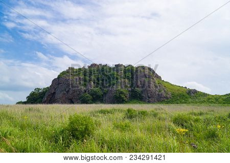 The Far Eastern Landscape Of The Krabbe Peninsula. Rocks Rise In The Field Against The Blue Sky